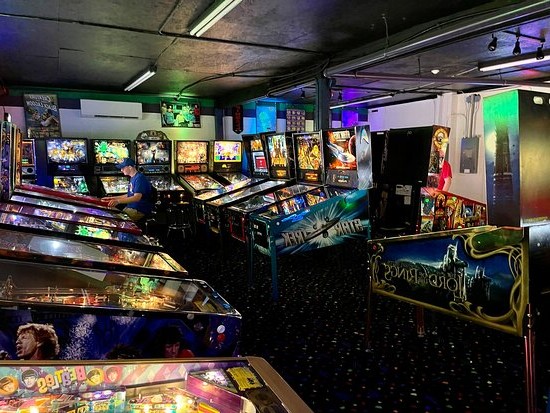 une salle d'arcade remplie de flippers